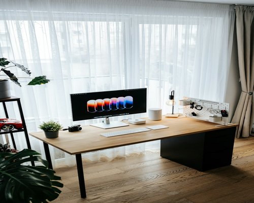 Comfortable home office setup with appropriate distance from the monitor screen and natural light filtering